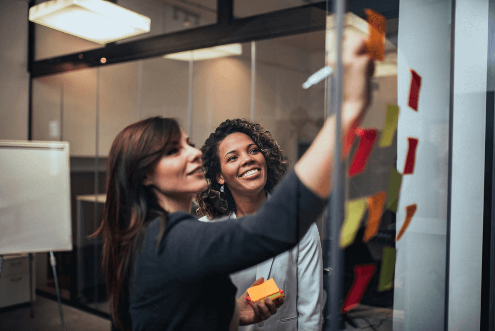 Image - Two workers in hard hats looking at documents