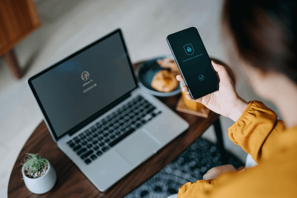 Image - Woman in orange top working at desk with laptop